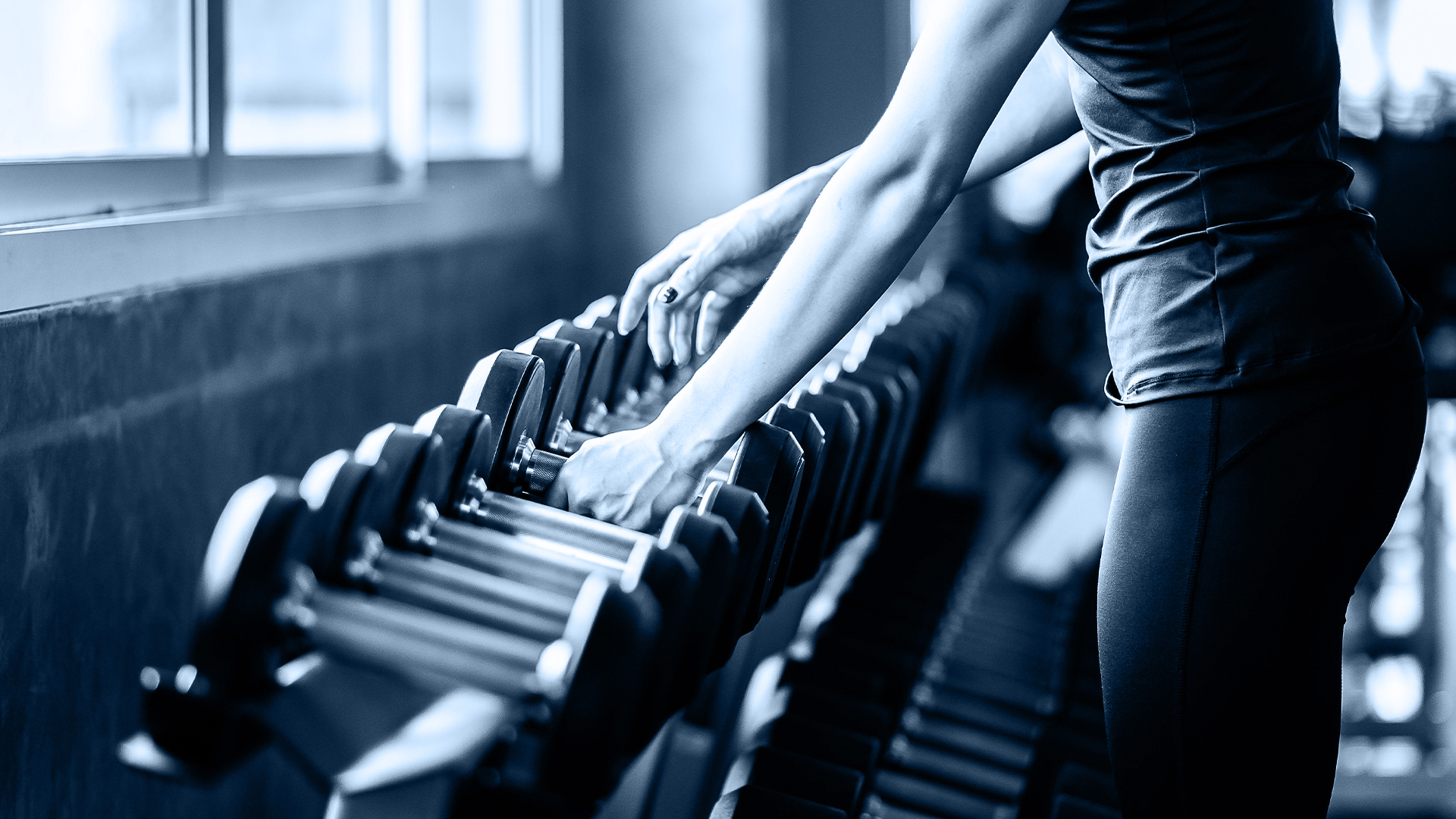 Member selecting dumbbells in Hillgrove Hotel Fitness Club gym